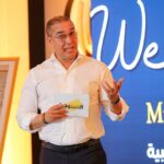 شخص يحمل بطاقة عليها حرف "SE" باللاتينية