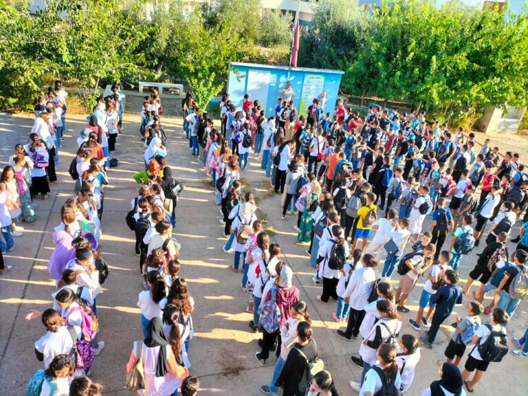 مجموعة من الطلاب بزي موحد أمام مبنى تعليمي